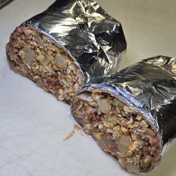 Two Los 3 Regios Mexican Restaurant burritos, cut in half, revealing a hearty filling of meat, potatoes, and beans.