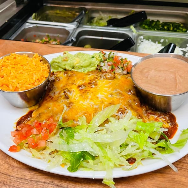 A plate of cheesy enchiladas with rice, refried beans, guacamole, pico de gallo, and lettuce.